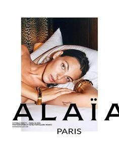 a woman laying on top of a bed in front of a poster with the word alla paris