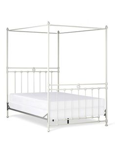 a white metal bed frame with four posts