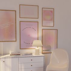 a white chair sitting in front of a table next to a lamp and pictures on the wall