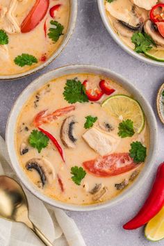 three bowls filled with soup and vegetables on top of a table