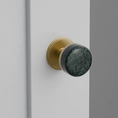 a door handle with a green marble knob on the side of a white door,