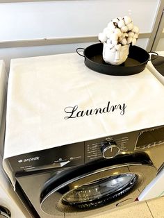 a white dish towel with the word laundry on it sitting on top of an appliance