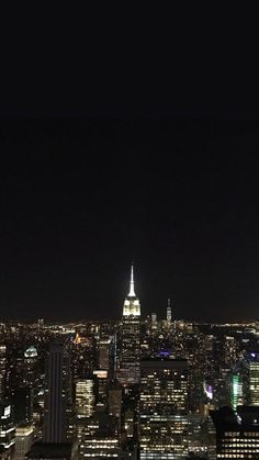 the empire building is lit up at night in new york's cityscape