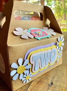 a brown box with flowers and the word wow on it sitting on a wooden table