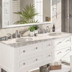 a bathroom with two sinks and a large mirror over it's counter top,