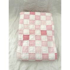 a pink and white checkered blanket on a bed