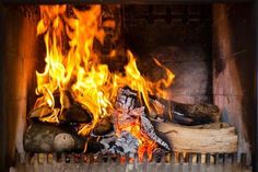 a fire burning in a fireplace next to logs