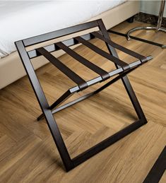 a bed sitting on top of a wooden floor next to a metal frame foot board