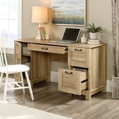 a computer desk with drawers and a laptop on it