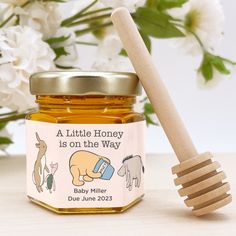 a honey jar with a wooden spoon next to it