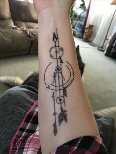 a woman's arm with an arrow and arrows tattoo on the left side of her arm