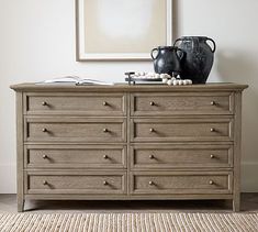 a dresser with two vases on top of it