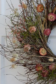 a wreath with dried flowers on the front door