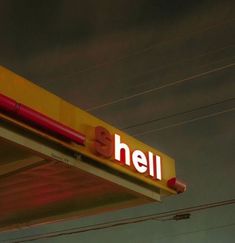 a yellow and red gas station sign with the word hell on it's side