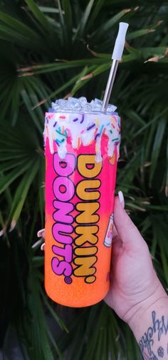 a person holding up a drink with sprinkles on it and a straw in their hand