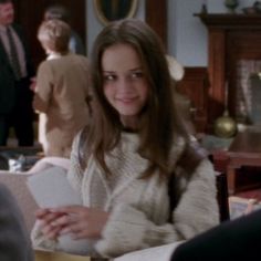 a woman sitting at a table in front of other people