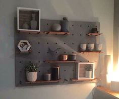 some shelves with pots and vases on them in the corner of a living room