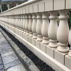 a stone fence with an umbrella on the top and side walk in front of it