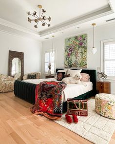 a bedroom with white walls, wood floors and a large bed in the middle of the room