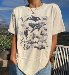 90s Tattoo Sea Animal Shirt, Vintage Dolphin Shirt, Retro Ocean Nature Shirt, Unisex Relaxed Adult Tee, Ocean Shirt, Whale Shirt, Sealife ⭐ INFORMATION: This unisex style t-shirt is suitable for both men and women. For care, wash the item inside out in cold water. Avoid bleach, dry cleaning, and direct ironing on the design. ⭐ MATERIAL DETAILS: Our heavyweight classic unisex tee is made from 5.3-ounce, 100% cotton, with variations of 99/1 cotton/poly (Ash) & 90/10 cotton/poly (Sport Grey). It fe Grunge Style Printed Short Sleeve Tops, Grunge Short Sleeve Printed Tops, Summer Grunge Tops With Relaxed Fit, Summer Grunge Style Relaxed Fit Top, 90s Style Summer Shirt With Funny Print, Grunge Shirt With Funny Print For Summer, Summer Grunge Shirt With Funny Print, Grunge Tops With Funny Print For Summer, Summer Grunge Tops With Funny Print