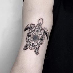 a black and white photo of a turtle tattoo on the arm