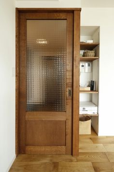 a wooden door with glass on the side and shelves in the back area behind it