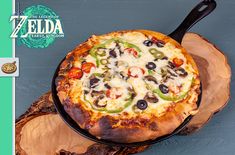 a pizza sitting on top of a wooden cutting board next to a green and white sign