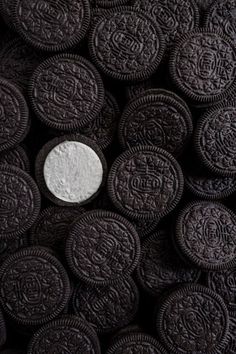 an oreo cookie with white chocolate in the middle surrounded by other cookies and oreos