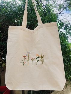 a white bag with flowers embroidered on it