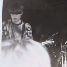 a young man is playing the drums in front of an audience