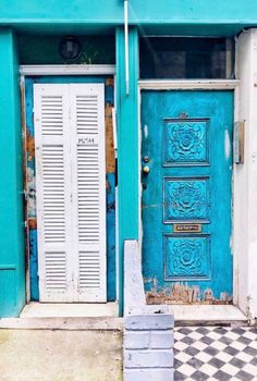 two blue doors are open in front of a checkered floor