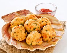 some food is sitting on a plate and ready to be eaten with dipping sauce in the background