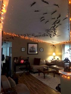 a living room filled with furniture and lots of lights hanging from the ceiling above it