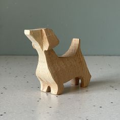 a wooden toy dog sitting on top of a table