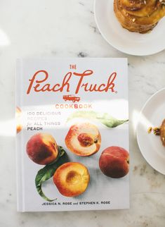 the peach truck cookbook sits on a marble table next to two plates with pastries