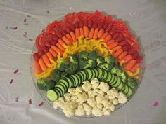 a platter filled with vegetables and cauliflower on top of a white table cloth