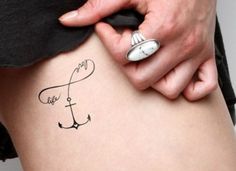 a woman's stomach with an anchor tattoo on her lower side and the words, love