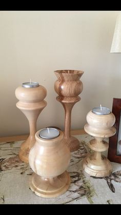 three wooden candlesticks sitting on top of a table