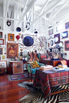 a living room filled with furniture and pictures on the wall next to a zebra rug