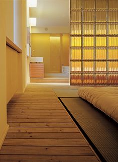 a bed sitting on top of a wooden floor next to a window