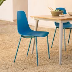 a table with two blue chairs and a bowl of food on top of the table