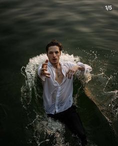 a man in white shirt riding on top of a surfboard