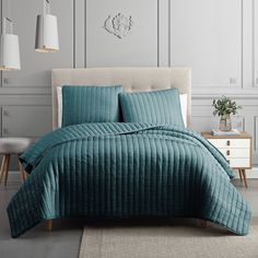 a bed with blue comforter and pillows in a room