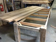 a bench made out of wooden planks in a shop with other woodworking tools