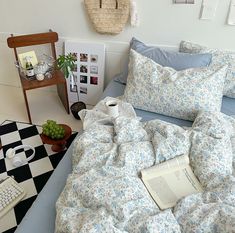 a bed covered in blue and white flowers next to a black and white checkered floor