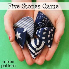 two hands holding small blue and white fabric bows with text overlay that reads five stones game