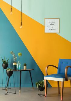 a blue chair sitting next to a table with potted plants on it