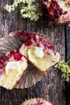 two muffins sitting on top of paper next to flowers