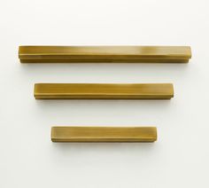 three brass handles on a white background