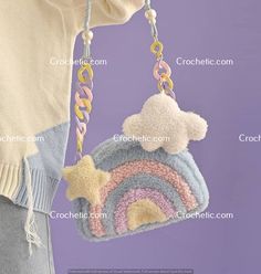 a crocheted purse with a rainbow and cloud hanging from it's side